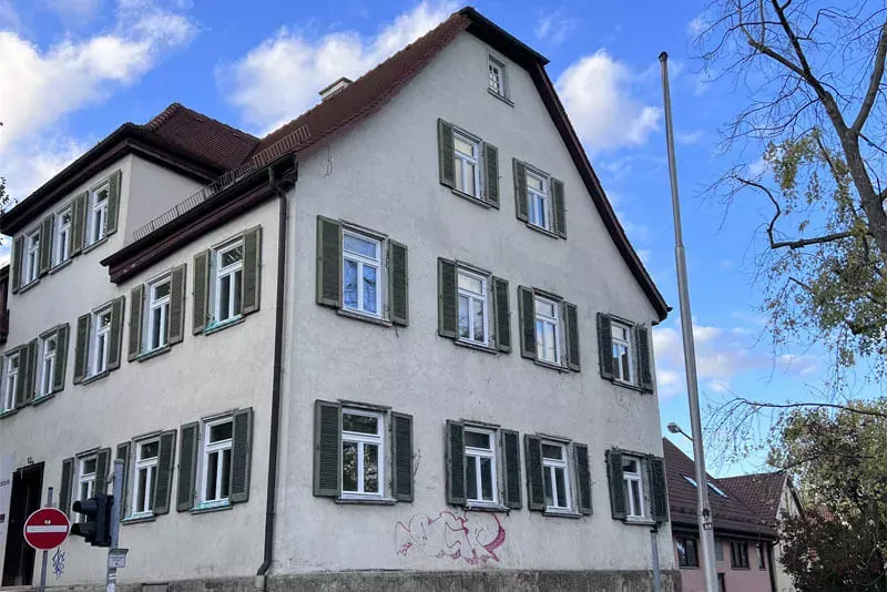 Sanierte Altbaufassade mit grünen Fensterläden